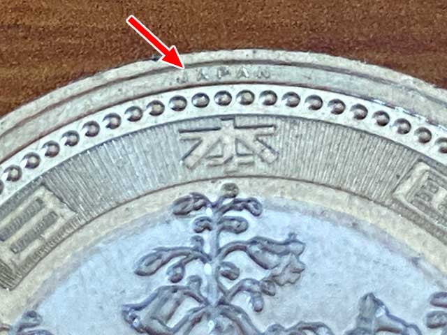 新500円玉は貨幣表面の上側と下側に「JAPAN」という微細文字がある