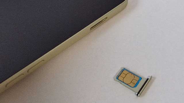 新iPhoneのSIMトレイに、旧iPhoneから取り出したSIMカードを金属面を上にして乗せる