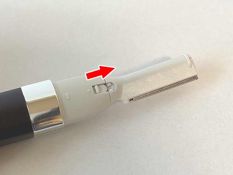 シェーバーの先端にうぶ毛用刃のシェーバーを取り付け、刃脱着ボタンを矢印方向にスライドすると、刃が固定される