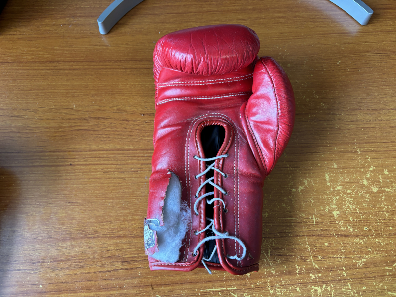 革が破れて綿がはみ出ているボクシンググローブ