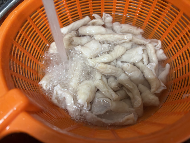 茹で上がった豚ホルモンを水洗い